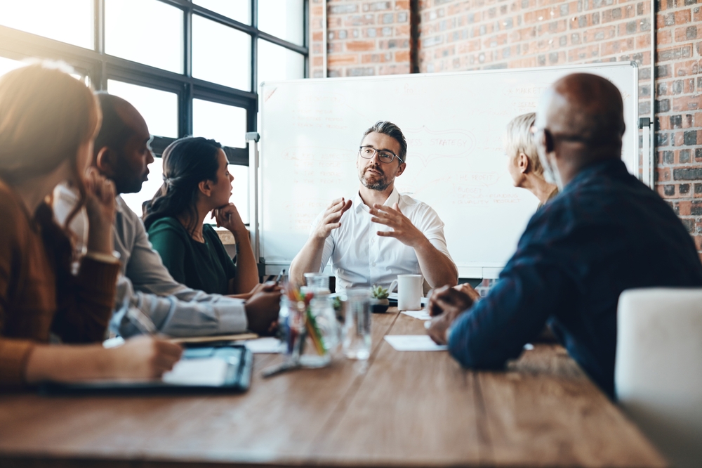 Man, manager and meeting or presentation in boardroom with coworkers for corporate business seminar.