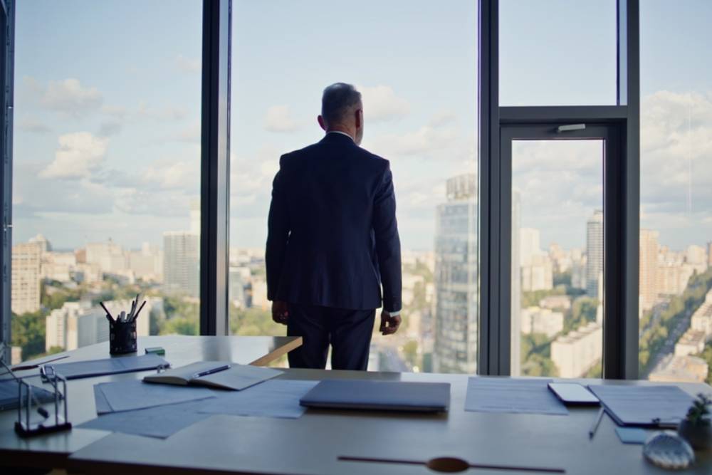Business owner contemplating city view from modern office workplace